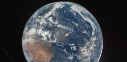 Una impresionante imagen de la Tierra desde el espacio, mostrando continentes, océanos y una enigmática luz que emerge de la atmósfera sobre el Atlántico. (NASA)