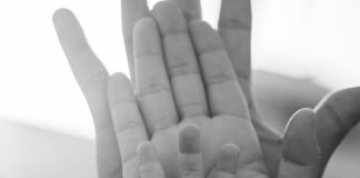 close up of parents and child palms together